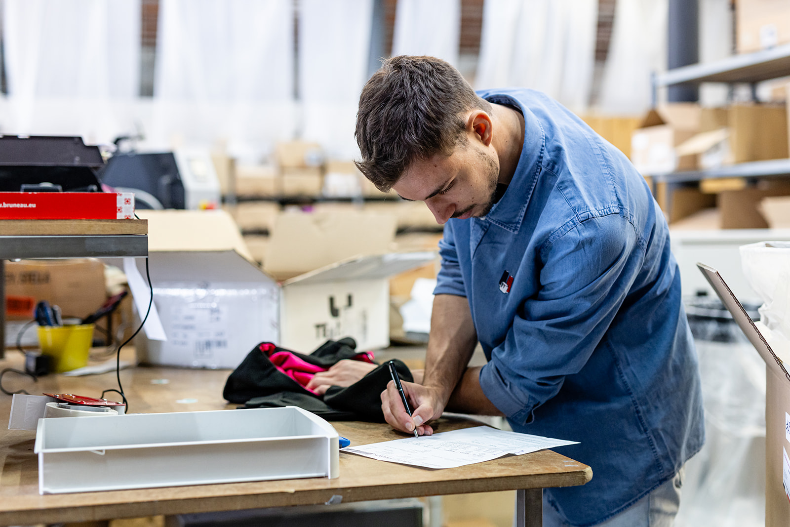 Préparation et contrôle d’une commande de vêtements personnalisés avant expédition dans l’atelier Mes Tenues Perso
