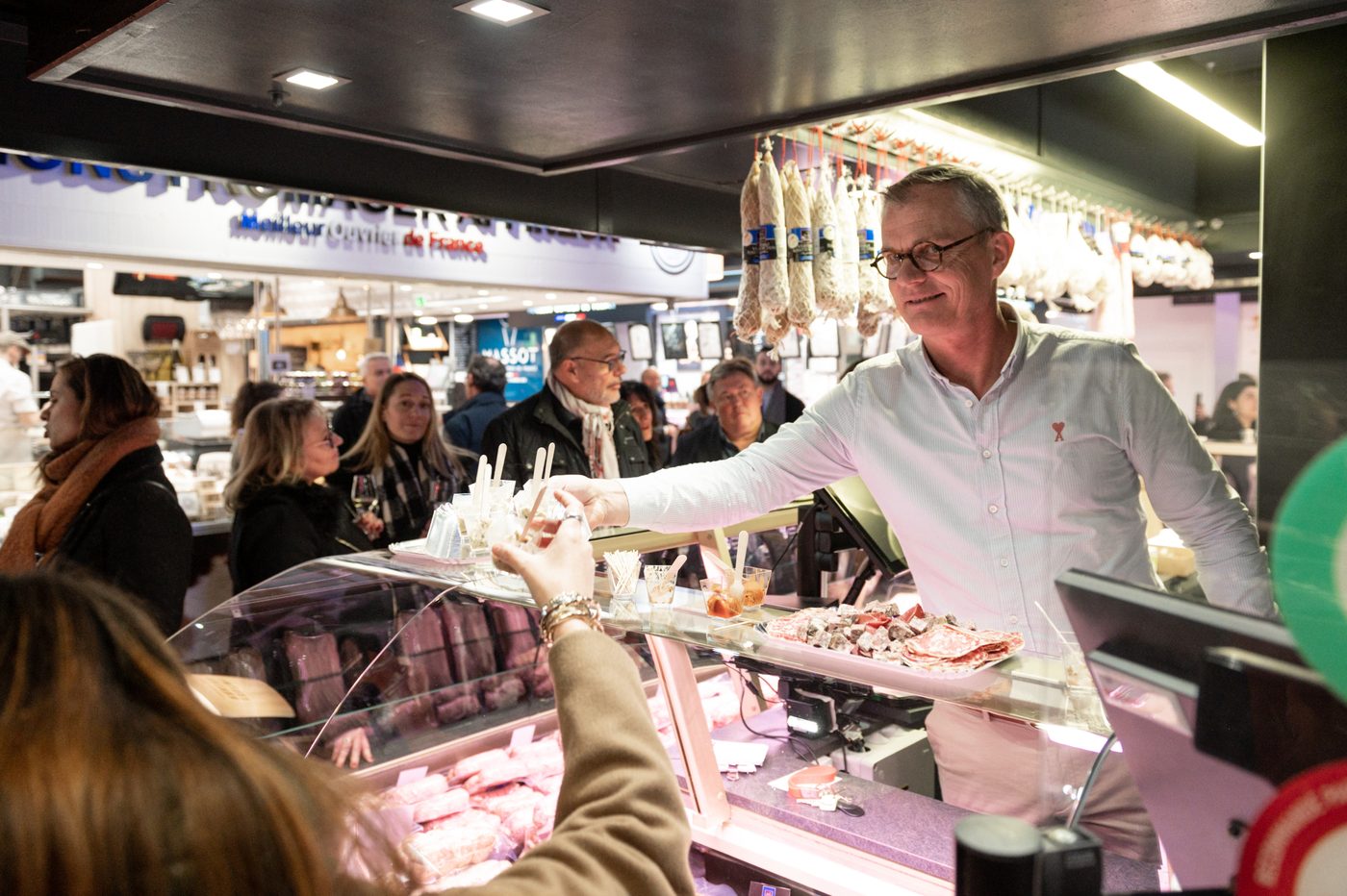 Commercial en chemise personnalisée servant des visiteurs sur un stand du Sirha Lyon 2023