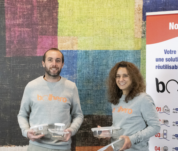 Deux personnes portant des sweats gris personnalisés sur un stand
